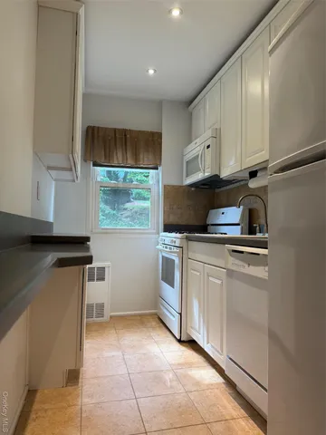 a kitchen with a refrigerator sink and cabinets