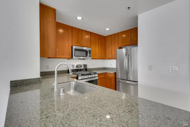 a kitchen with stainless steel appliances granite countertop a sink stove and refrigerator
