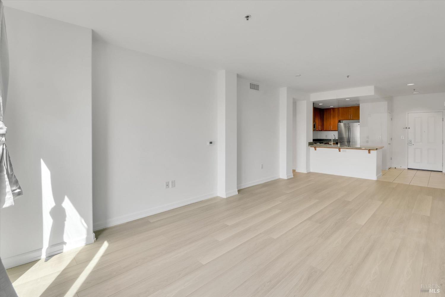 423 7th Street, Unit 105 Oakland, CA 94607 - Photo 15 of 28 a view of empty room with wooden floor and window