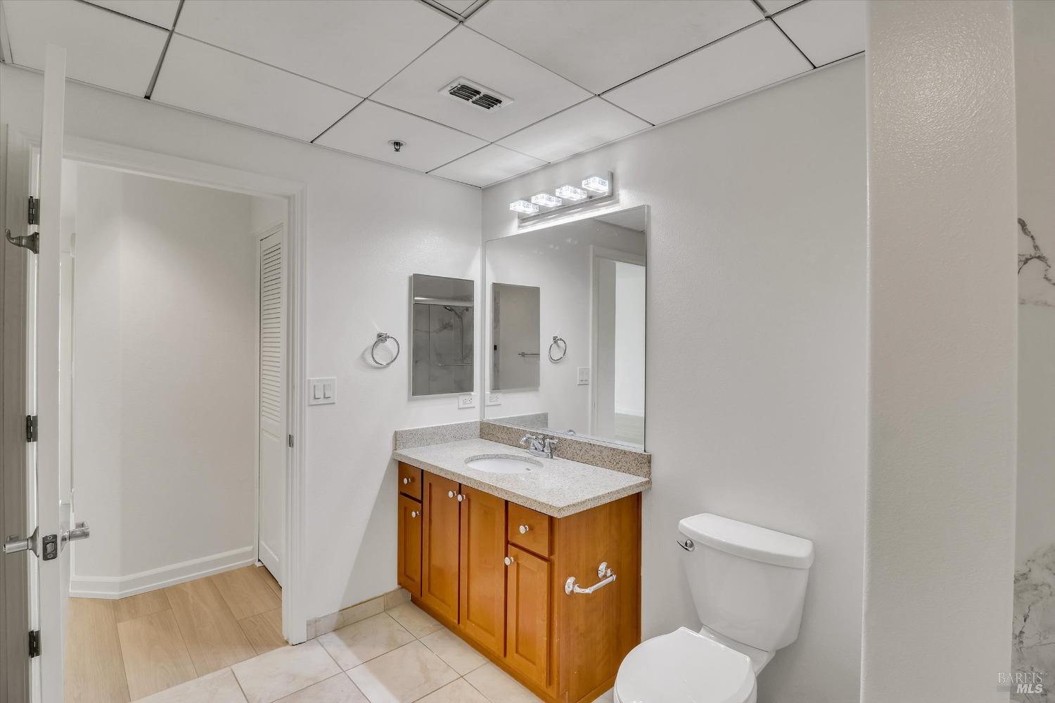 423 7th Street, Unit 105 Oakland, CA 94607 - Photo 25 of 28 a bathroom with a granite countertop sink toilet and shower