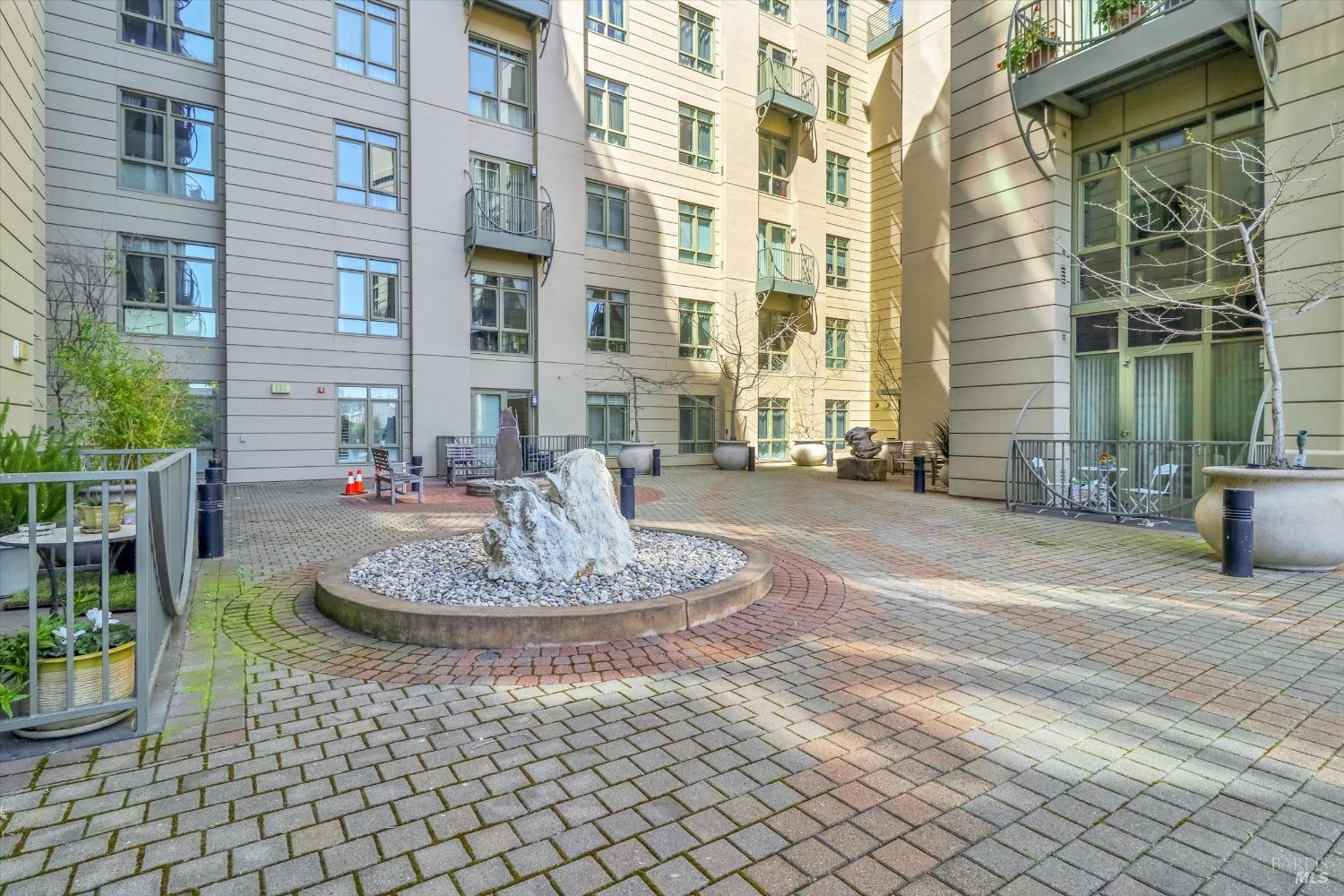 423 7th Street, Unit 105 Oakland, CA 94607 - Photo 26 of 28 a large building with a bench in front of it
