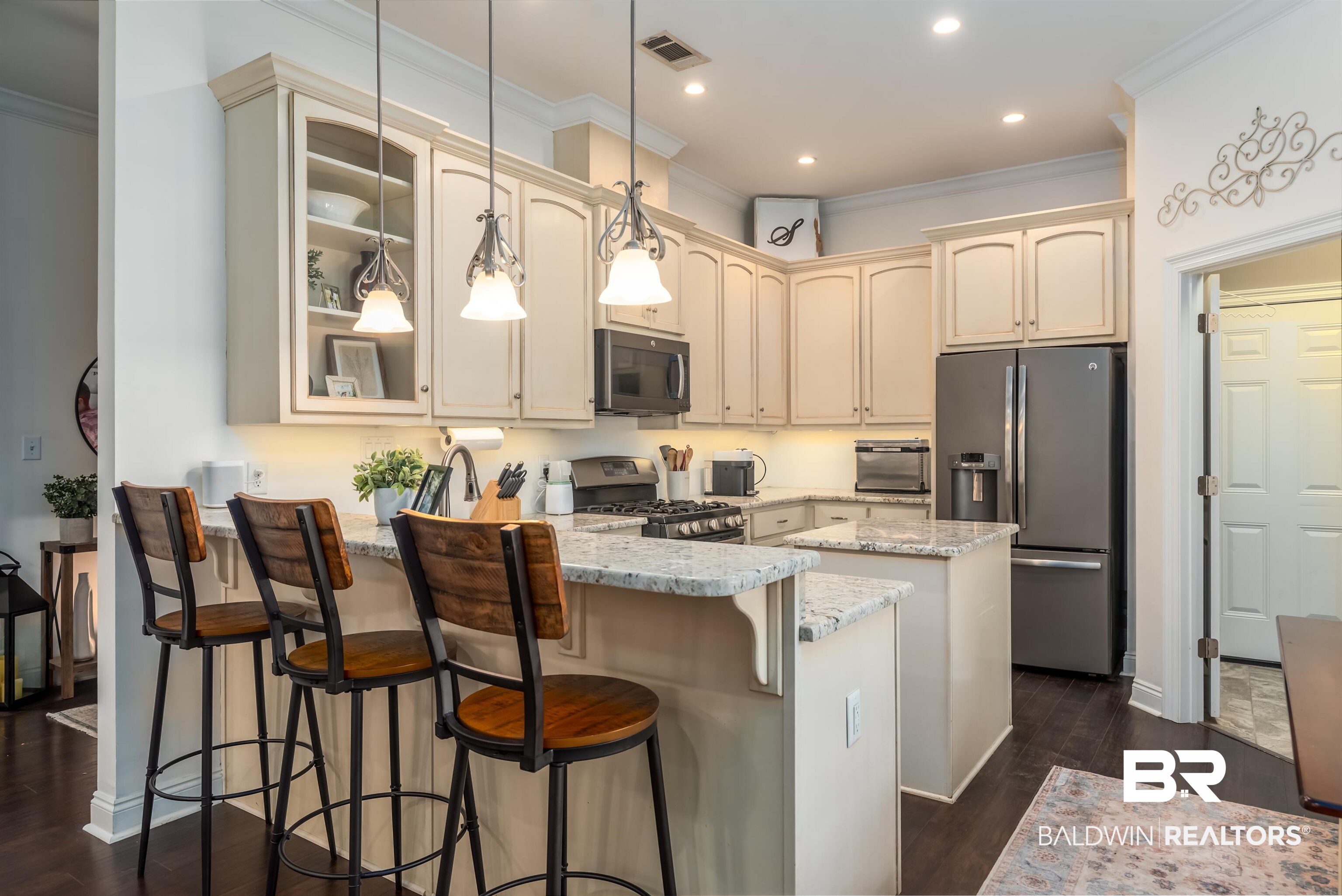 965 Henckley Avenue Mobile, AL 36609 - Photo 7 of 30 Kitchen with dark wood-type flooring, cream cabinetry, decorative light fixtures, kitchen peninsula, and stainless steel appliances