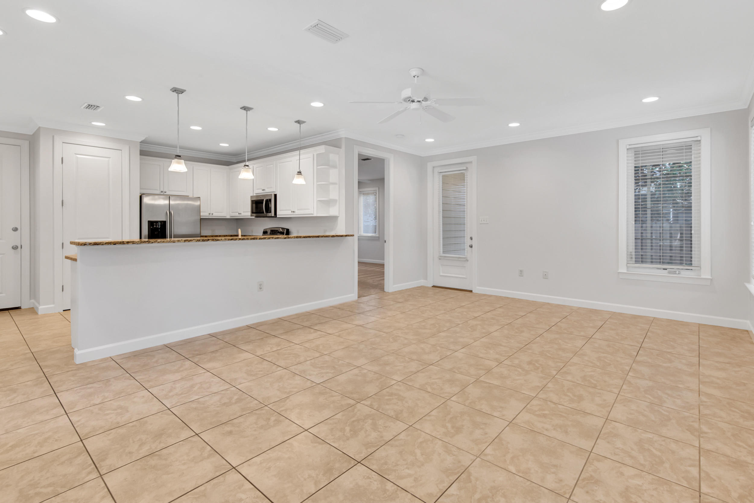 198 South Zander Way Santa Rosa Beach, FL 32459 - Photo 5 of 37 a large white kitchen with kitchen island a sink a counter and a stove top oven