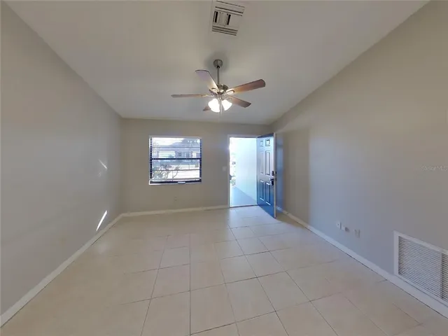 an empty room with fan and windows