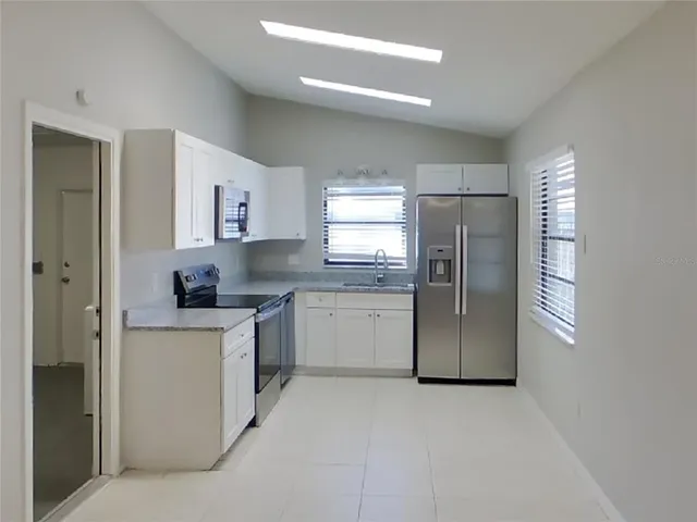 an empty room with a ceiling fan and a window