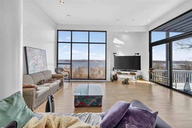 a living room with furniture a flat screen tv and a large window