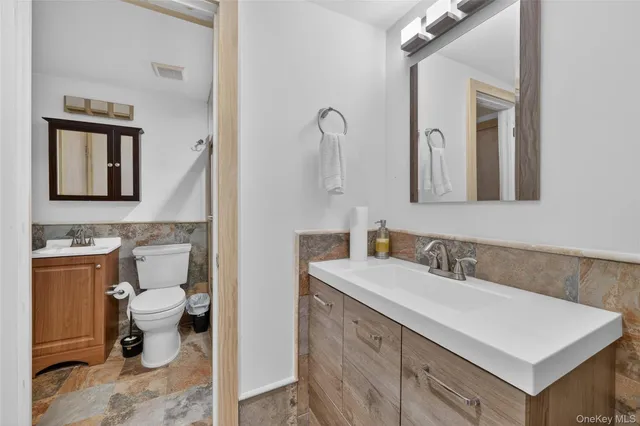a bathroom with a sink vanity mirror and toilet