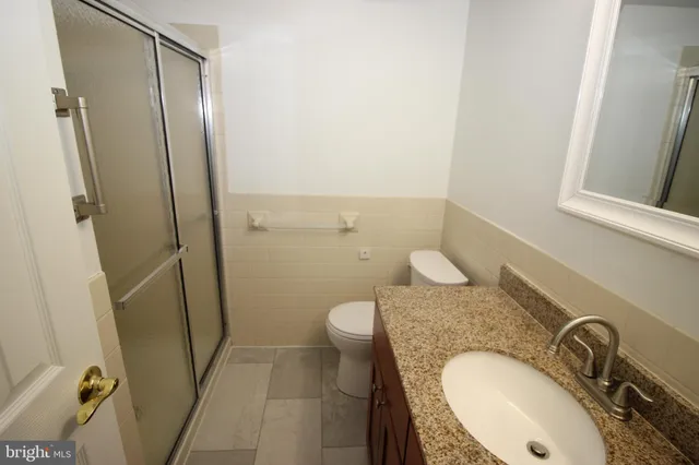 a bathroom with a granite countertop sink toilet and shower