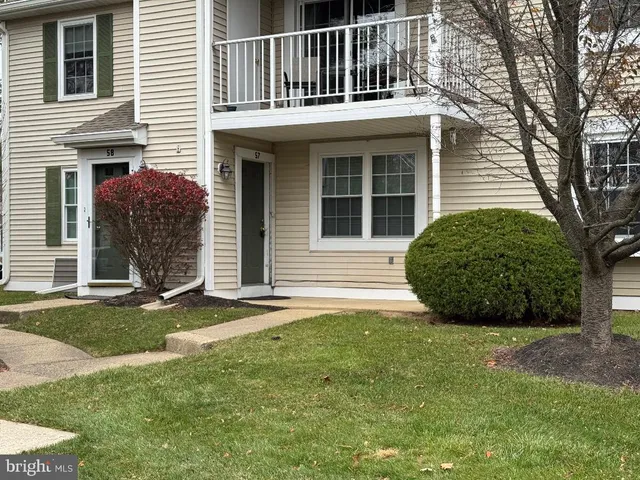 a view of a house with a yard and large tree