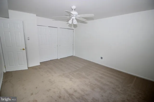 an empty room with a ceiling fan and fan