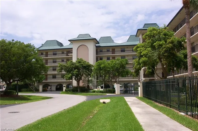 a front view of a building with a garden and plants