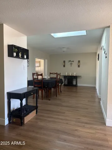 a living room with furniture and a dining table with wooden floor