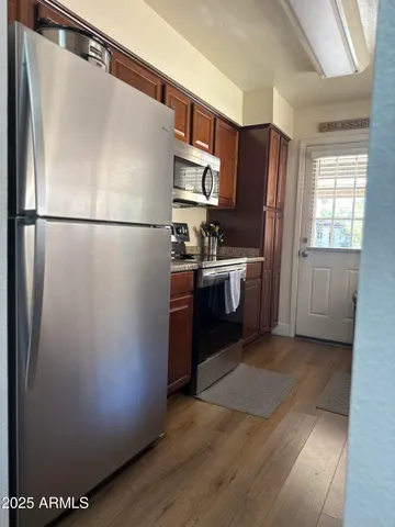 a kitchen with stainless steel appliances granite countertop a refrigerator a stove a sink and a refrigerator