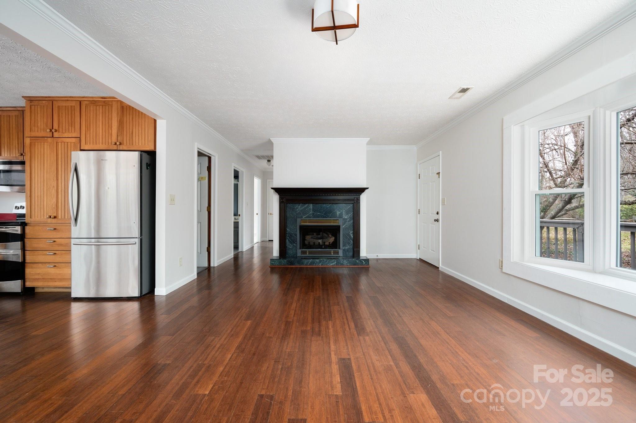 148 Pinecrest Drive Alexander, NC 28701 - Photo 12 of 31 a view of an empty room with wooden floor fireplace and a window