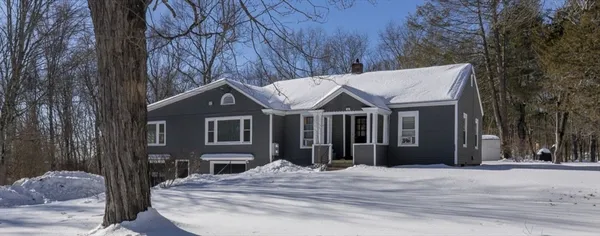 a view of a house with a yard and large trees