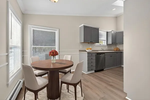 a kitchen with stainless steel appliances kitchen island a table chairs in it and wooden floors