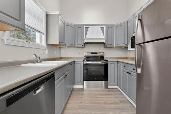 a kitchen with white cabinets and white appliances