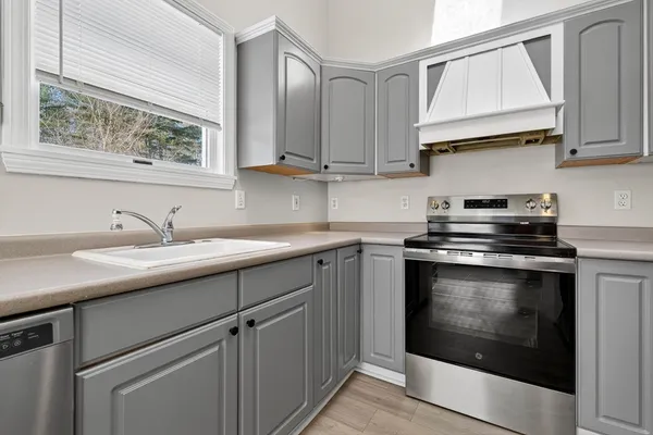 a kitchen with stainless steel appliances granite countertop a sink a stove and cabinets
