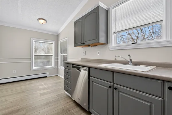 a kitchen with a sink cabinets and a wooden floor