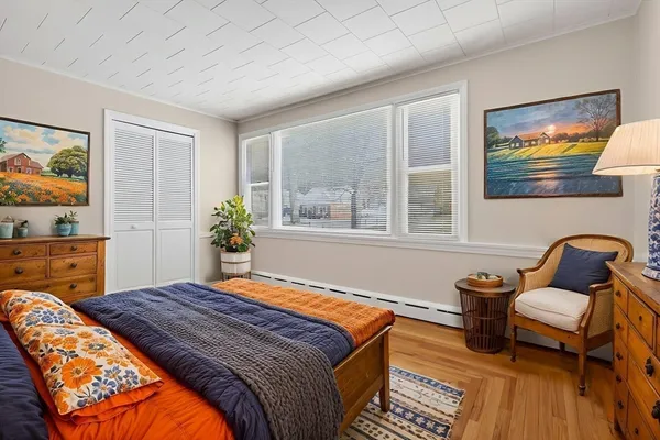 a bedroom with a bed and wooden floor