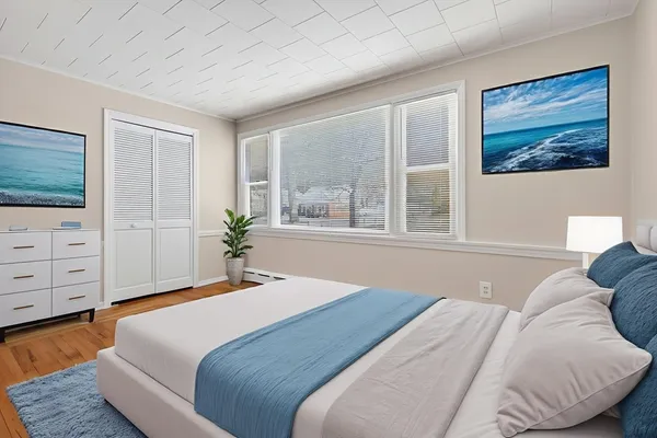 a bedroom with a large bed and dresser with mirror