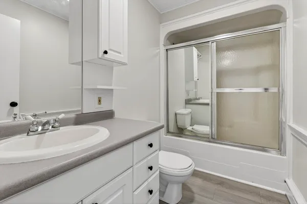 a bathroom with a sink a toilet and shower