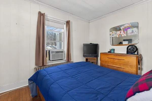a bedroom with a bed and wooden floor