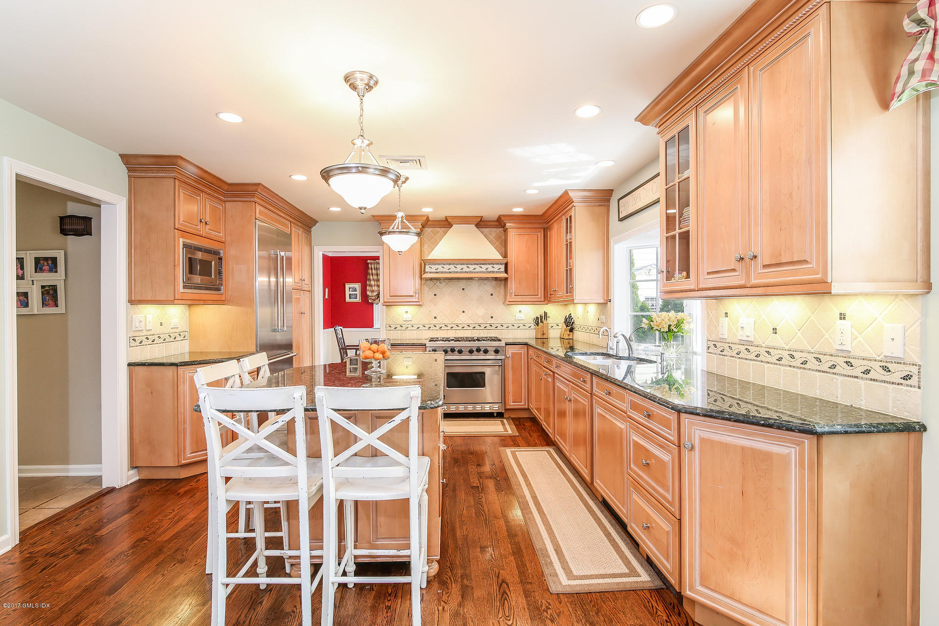 22 Griffith Road Riverside, CT 06878 - Photo 11 of 40 a kitchen with stainless steel appliances granite countertop wooden floor window and cabinets