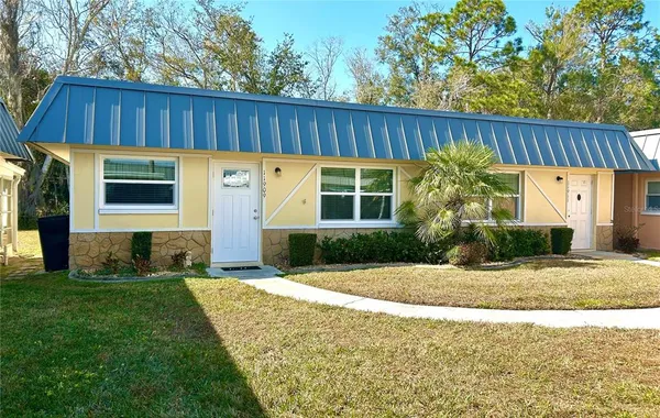 a view of a house with a small yard and wooden fence