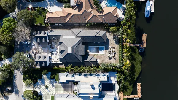 an aerial view of a house with a yard potted plants and large tree