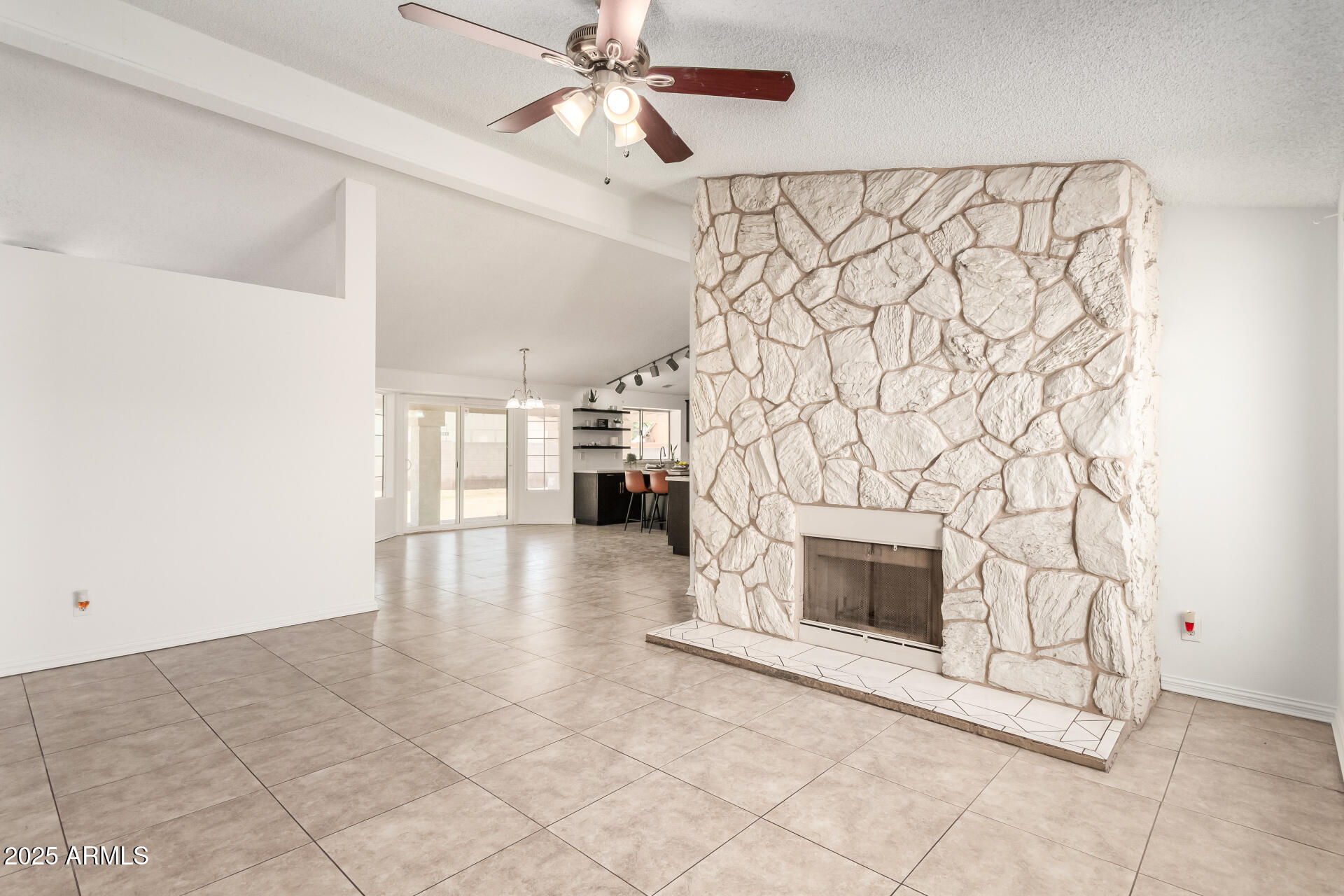 3419 North 70th Avenue Phoenix, AZ 85033 - Photo 5 of 31 a view of a livingroom with a fireplace a ceiling fan and brick wall