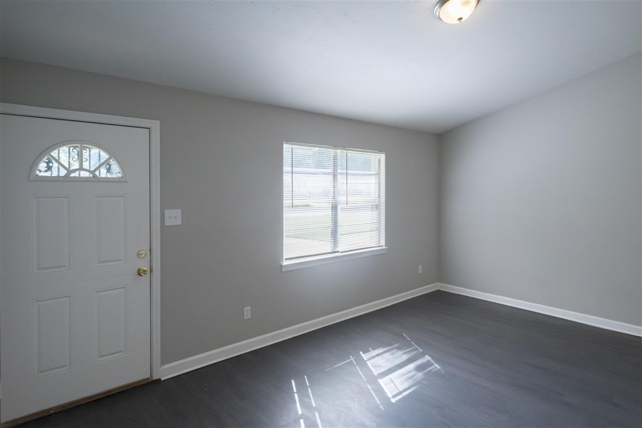 1494 Winfield Road Memphis, TN 38116 - Photo 11 of 20 an empty room with wooden floor and windows