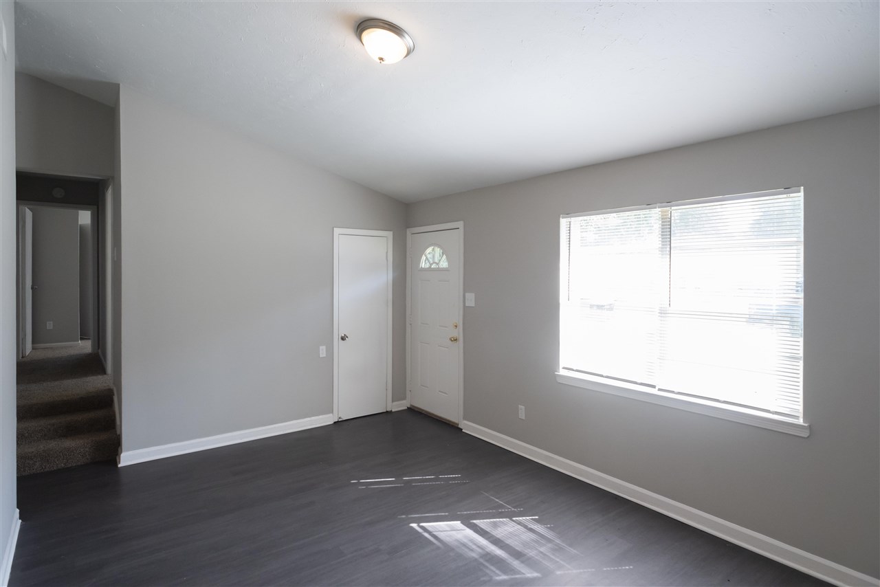 1494 Winfield Road Memphis, TN 38116 - Photo 9 of 20 an empty room with wooden floor and windows