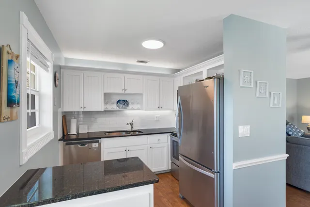a kitchen with stainless steel appliances granite countertop a stove refrigerator and microwave