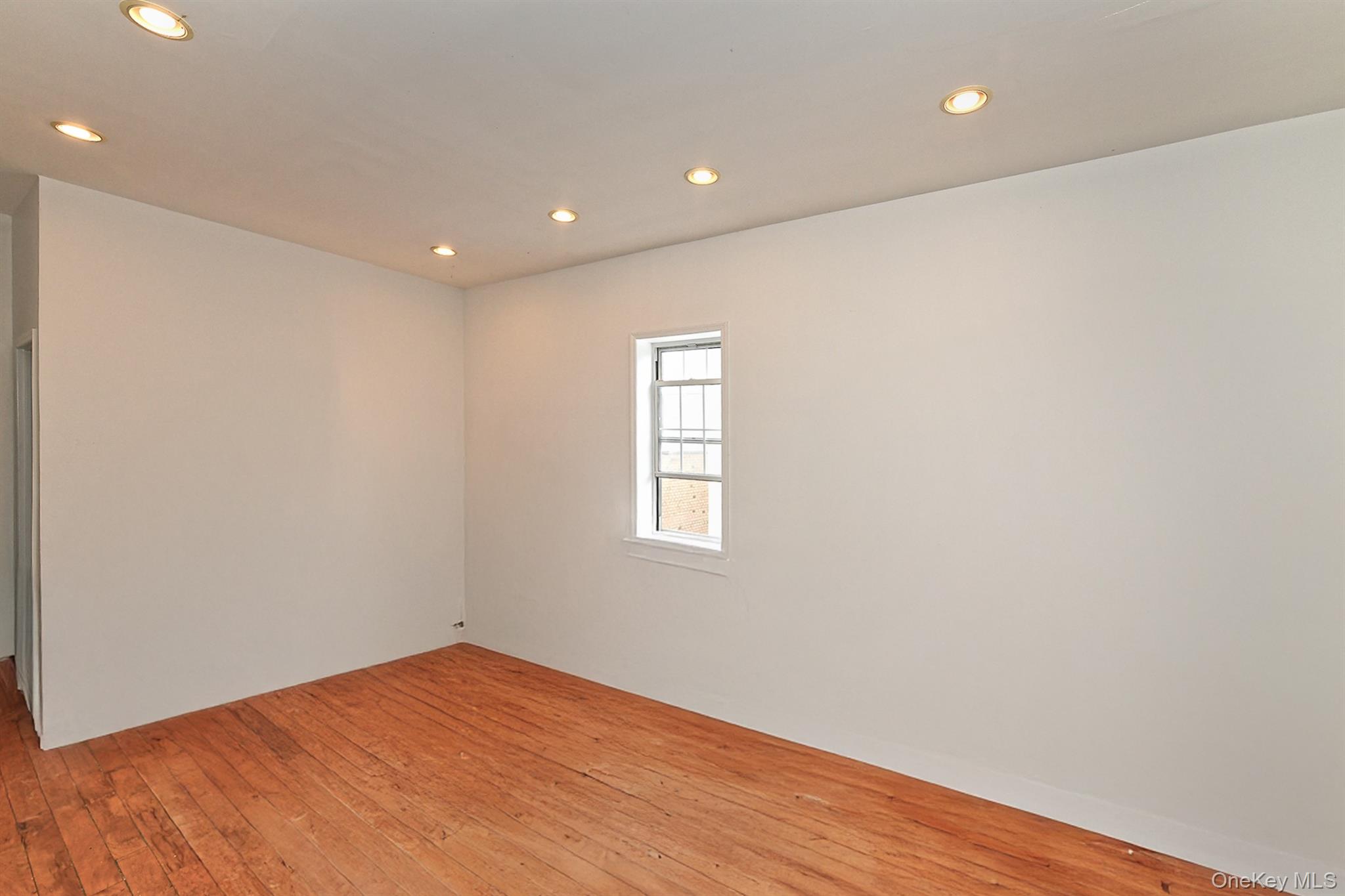1244 Jefferson Avenue Brooklyn, NY 11221 - Photo 11 of 21 a view of an empty room with wooden floor and a window