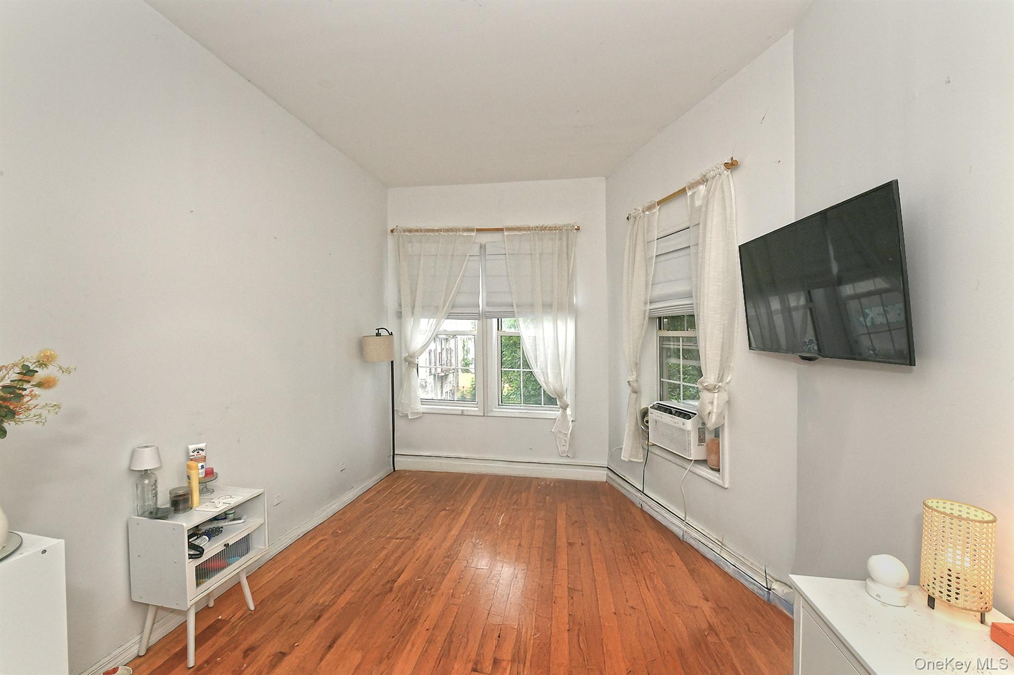 1244 Jefferson Avenue Brooklyn, NY 11221 - Photo 12 of 21 a view of a livingroom with wooden floor and a flat screen tv