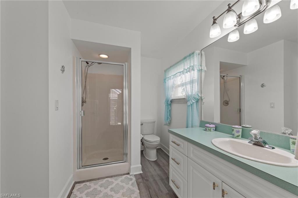 13541 Stringfellow Road Bokeelia, FL 33922 - Photo 23 of 49 a bathroom with a granite countertop sink a toilet and shower