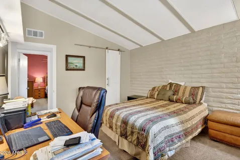 a bedroom with two beds and a chair