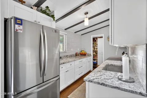 a kitchen with granite countertop a refrigerator and a sink