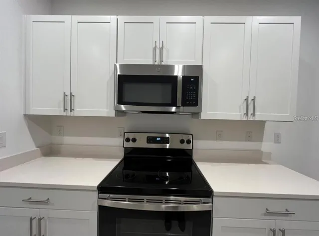 a kitchen with appliances a sink and cabinets