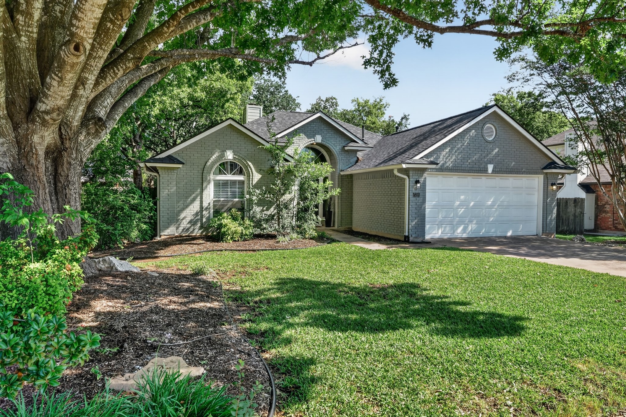 1811 Old Mill Road Cedar Park, TX 78613 - Photo 2 of 39 A classic brick exterior home with a two-car garage and a neatly manicured lawn awaits.