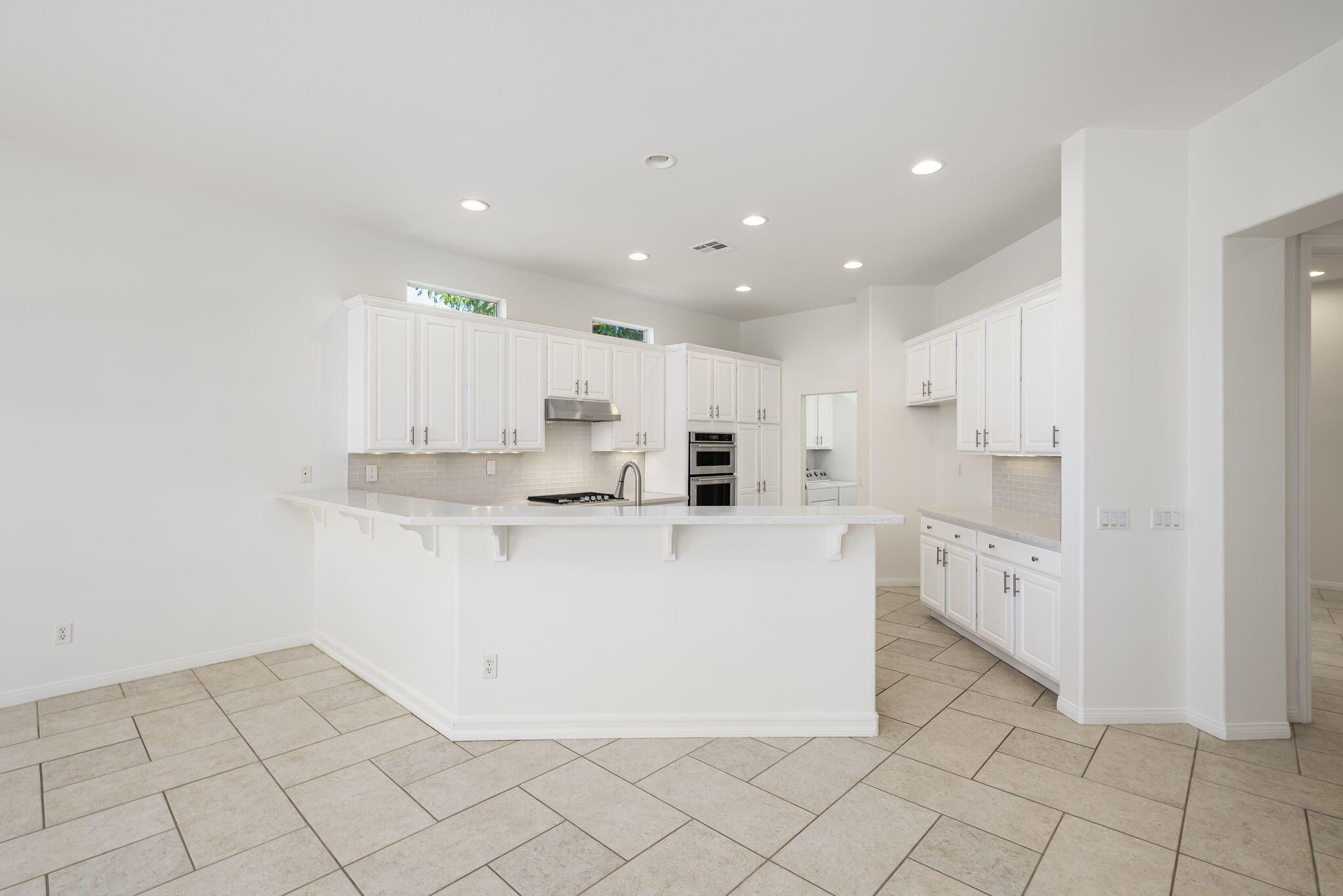 44528 Knightswood Road Indio, CA 92201 - Photo 15 of 46 a large white kitchen with white cabinets