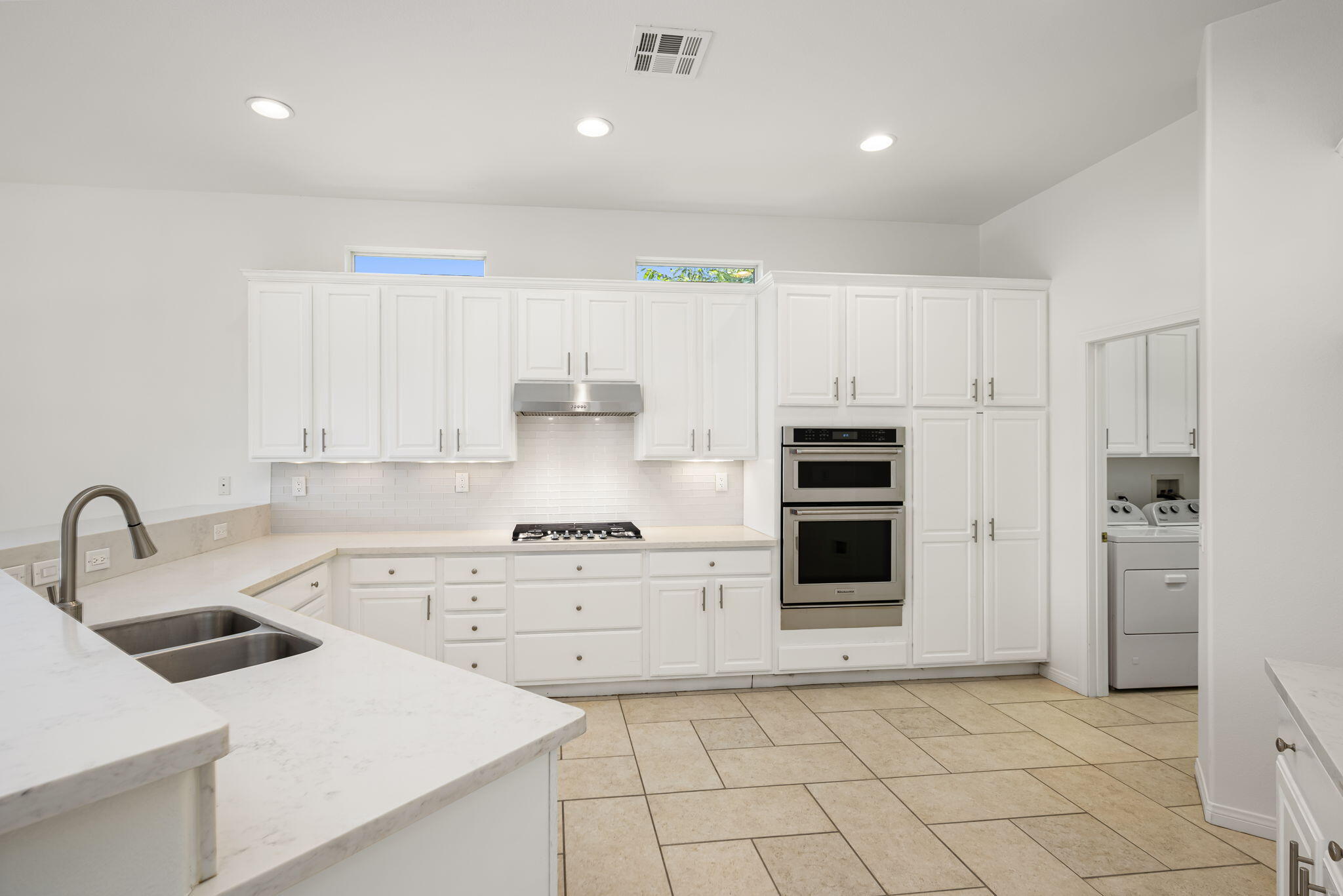 44528 Knightswood Road Indio, CA 92201 - Photo 17 of 46 a kitchen with white cabinets and stainless steel appliances
