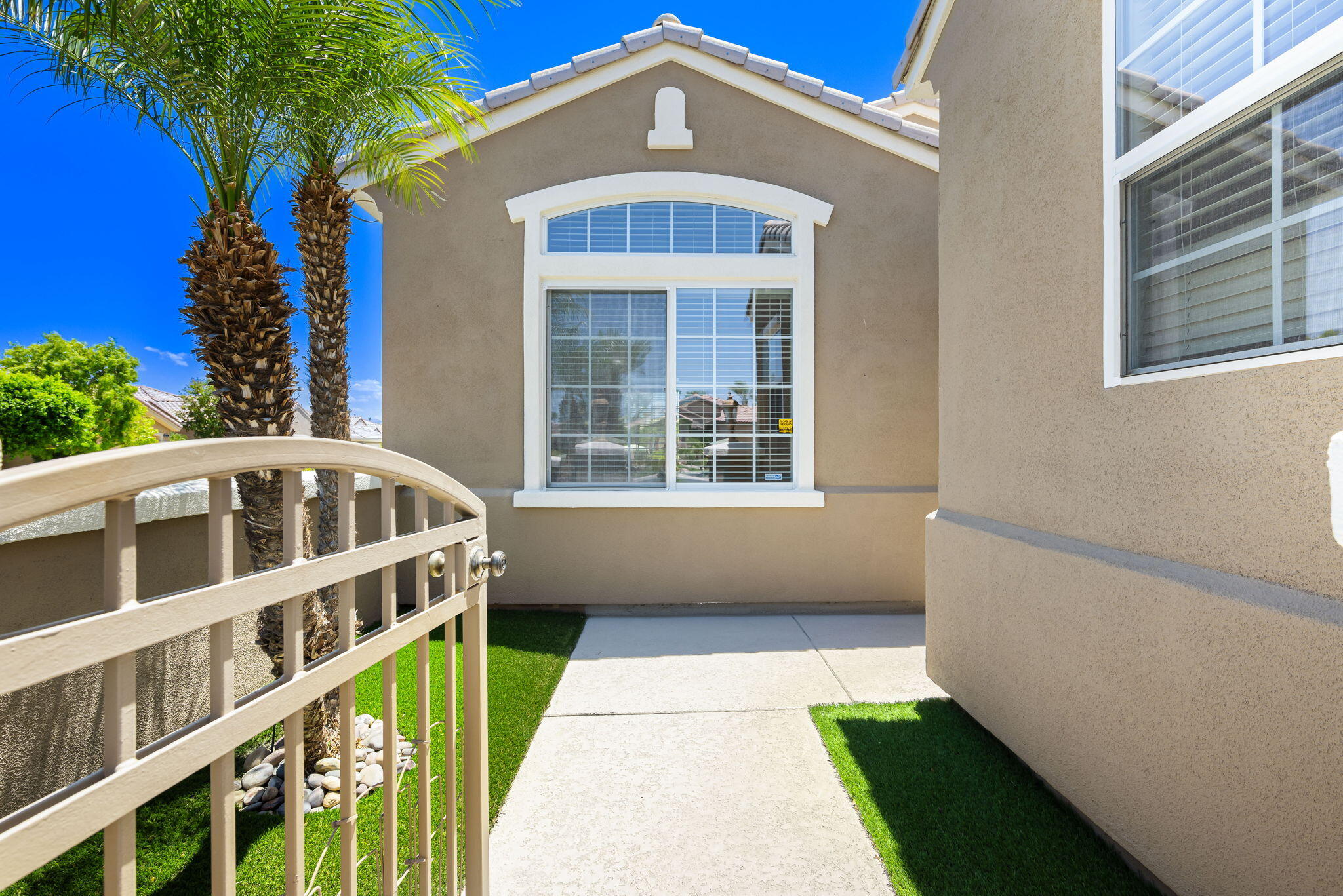 44528 Knightswood Road Indio, CA 92201 - Photo 5 of 46 a view of a brick house with large windows