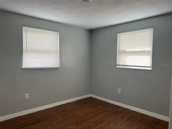 an empty room with wooden floor and a window