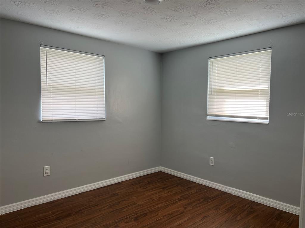 5046 Victoria Lane Holiday, FL 34690 - Photo 11 of 24 an empty room with wooden floor and a window