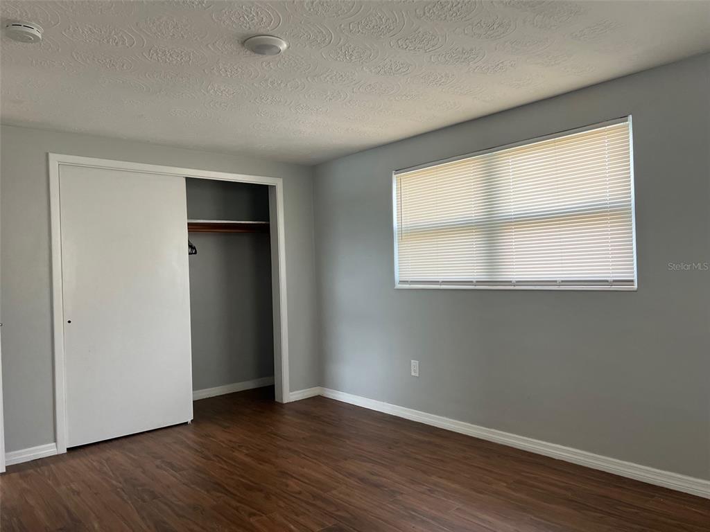 5046 Victoria Lane Holiday, FL 34690 - Photo 14 of 24 a view of an empty room with wooden floor and a window