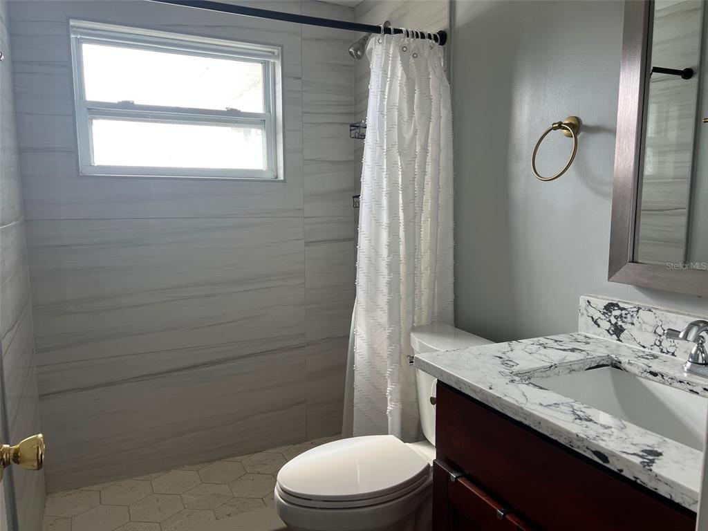 5046 Victoria Lane Holiday, FL 34690 - Photo 16 of 24 a bathroom with a granite countertop sink toilet and shower