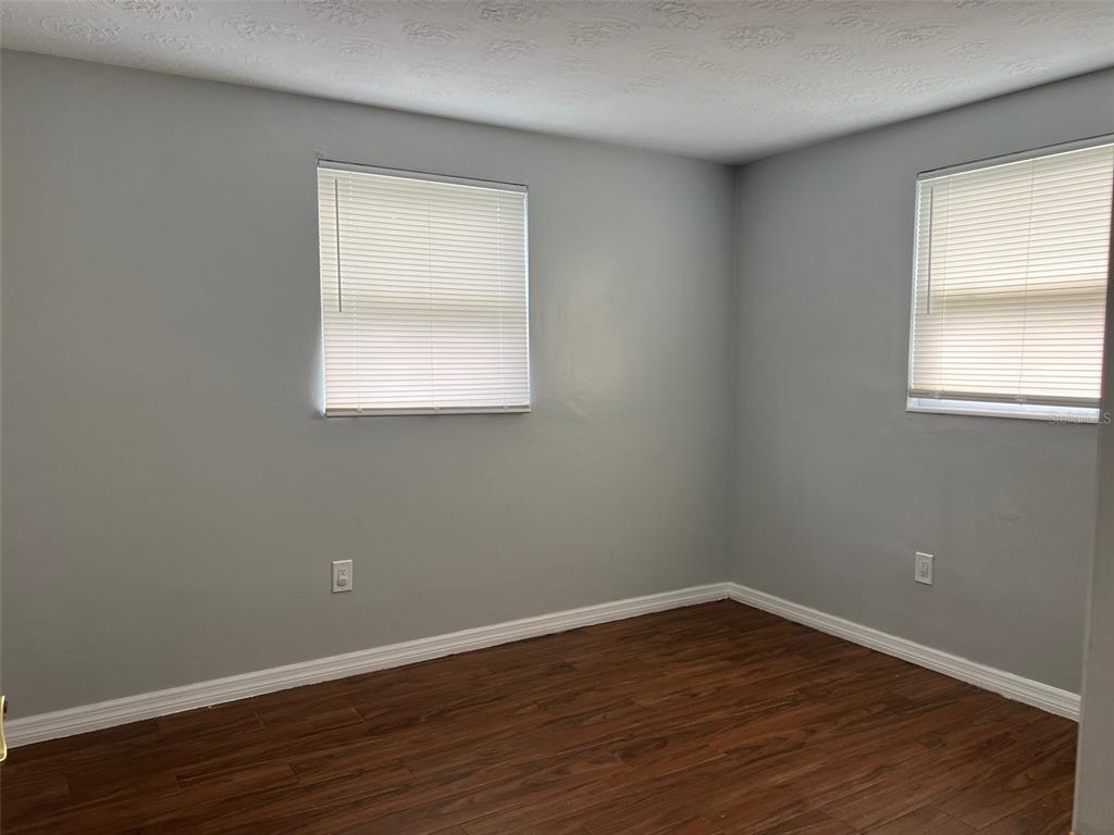 5046 Victoria Lane Holiday, FL 34690 - Photo 17 of 24 an empty room with wooden floor and windows