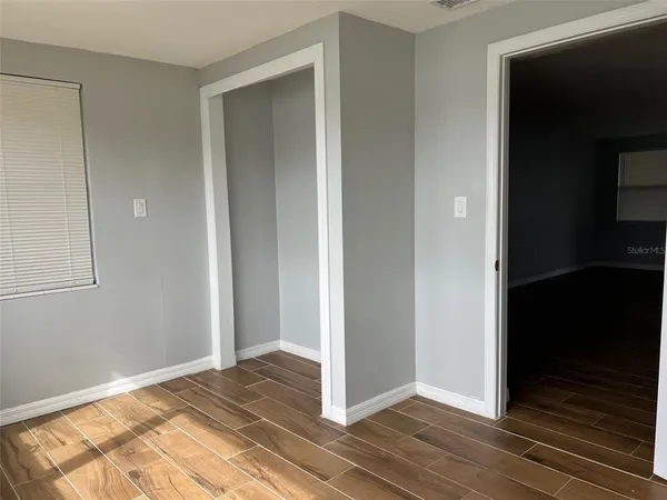 a view of a bedroom with wooden floor and bathroom